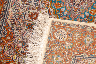 Two Oriental rugs with floral design, wool and silk on cotton, 20th C.