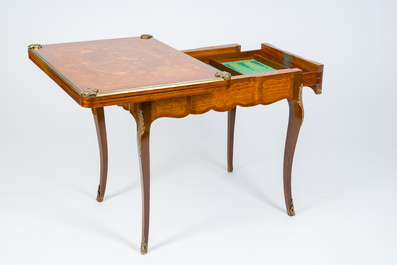 A French bronze mounted wood game table with marquetry top, 19th/20th C.