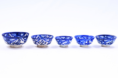Fourteen blue and white Islamic pottery bowls and plates with floral design, Persia and/or North Africa, 19th C.