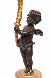 A pair of French patinated and gilt bronze three-light candlesticks in the form of a putto carrying a bouquet of flowers, 19th C.