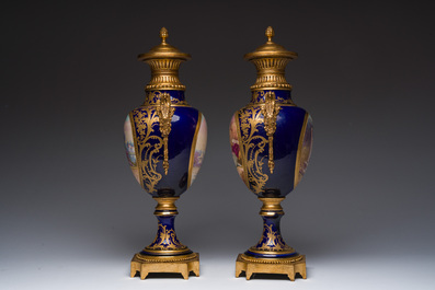 Paire de vases couvertes &agrave; fond bleu royale &agrave; la mani&egrave;re de S&egrave;vres aux montures dor&eacute;es et &agrave; d&eacute;cor de sc&egrave;ne d'amour, France, 20&egrave;me si&egrave;cle