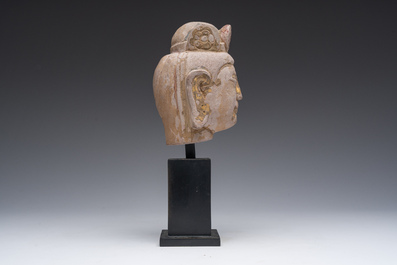 A Chinese sandstone head of Guanyin with traces of gilding and polychromy, probably Tang