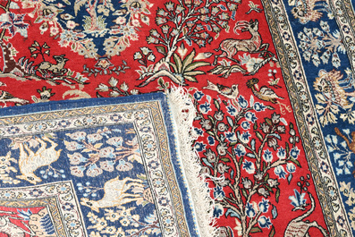 Deux tapis orientaux de type Qom (Qum/Ghom) &agrave; d&eacute;cor floral et d'animaux parmi des branches fleuries, laine sur coton, 20&egrave;me si&egrave;cle