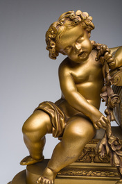 Garniture de chemin&eacute;e en trois pi&egrave;ces en bronze dor&eacute; &agrave; d&eacute;cor floral et de putti, France, 19&egrave;me/20&egrave;me si&egrave;cle