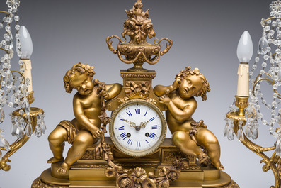 Garniture de chemin&eacute;e en trois pi&egrave;ces en bronze dor&eacute; &agrave; d&eacute;cor floral et de putti, France, 19&egrave;me/20&egrave;me si&egrave;cle