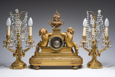 Garniture de chemin&eacute;e en trois pi&egrave;ces en bronze dor&eacute; &agrave; d&eacute;cor floral et de putti, France, 19&egrave;me/20&egrave;me si&egrave;cle