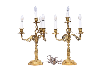 A pair of French Louis XV style gilt bronze four-light candlesticks with floral relief design, 19th/20th C.