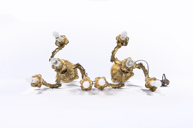 A pair of French Louis XV style gilt bronze four-light candlesticks with floral relief design, 19th/20th C.