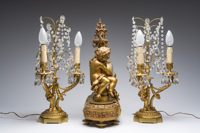 Garniture de chemin&eacute;e en trois pi&egrave;ces en bronze dor&eacute; &agrave; d&eacute;cor floral et de putti, France, 19&egrave;me/20&egrave;me si&egrave;cle