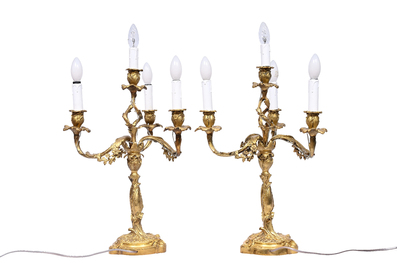 A pair of French Louis XV style gilt bronze four-light candlesticks with floral relief design, 19th/20th C.