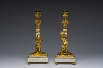 Paire de bougeoirs en bronze dor&eacute; et marbre blanc &agrave; d&eacute;cor de bacchantes, France, d&eacute;but du 19&egrave;me si&egrave;cle