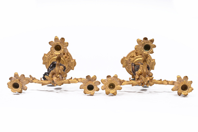 Garniture de chemin&eacute;e en trois pi&egrave;ces en bronze patin&eacute; et dor&eacute; couronn&eacute;e de deux putti avec un nid d'oiseau, France, 19&egrave;me si&egrave;cle