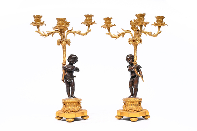 Garniture de chemin&eacute;e en trois pi&egrave;ces en bronze patin&eacute; et dor&eacute; couronn&eacute;e de deux putti avec un nid d'oiseau, France, 19&egrave;me si&egrave;cle