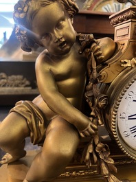 Garniture de chemin&eacute;e en trois pi&egrave;ces en bronze dor&eacute; &agrave; d&eacute;cor floral et de putti, France, 19&egrave;me/20&egrave;me si&egrave;cle