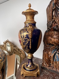 Paire de vases couvertes &agrave; fond bleu royale &agrave; la mani&egrave;re de S&egrave;vres aux montures dor&eacute;es et &agrave; d&eacute;cor de sc&egrave;ne d'amour, France, 20&egrave;me si&egrave;cle