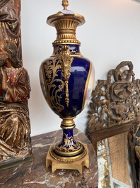 Paire de vases couvertes &agrave; fond bleu royale &agrave; la mani&egrave;re de S&egrave;vres aux montures dor&eacute;es et &agrave; d&eacute;cor de sc&egrave;ne d'amour, France, 20&egrave;me si&egrave;cle