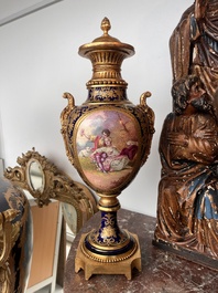 Paire de vases couvertes &agrave; fond bleu royale &agrave; la mani&egrave;re de S&egrave;vres aux montures dor&eacute;es et &agrave; d&eacute;cor de sc&egrave;ne d'amour, France, 20&egrave;me si&egrave;cle