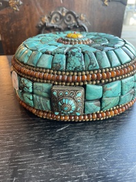 Een ronde Tibetaanse priesterhoed afgewerkt met o.m. turkoois en koperen parels, 20ste eeuw