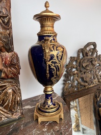 Paire de vases couvertes &agrave; fond bleu royale &agrave; la mani&egrave;re de S&egrave;vres aux montures dor&eacute;es et &agrave; d&eacute;cor de sc&egrave;ne d'amour, France, 20&egrave;me si&egrave;cle
