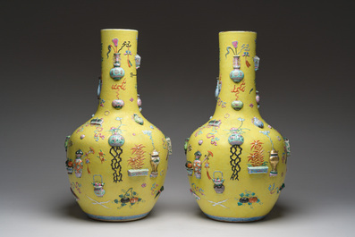 An exceptional pair of Chinese famille rose yellow sgraffito-ground bottle vases with applied design of antiquities, 19th C.