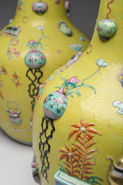 An exceptional pair of Chinese famille rose yellow sgraffito-ground bottle vases with applied design of antiquities, 19th C.