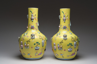 An exceptional pair of Chinese famille rose yellow sgraffito-ground bottle vases with applied design of antiquities, 19th C.