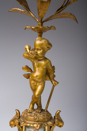 A French gilt bronze three-piece clock garniture with Erato, playful putti and S&egrave;vres style plaques, 19th C.
