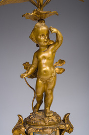 A French gilt bronze three-piece clock garniture with Erato, playful putti and S&egrave;vres style plaques, 19th C.