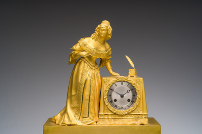 A fine French gilt bronze mantel clock crowned with a writing lady, 19th C.