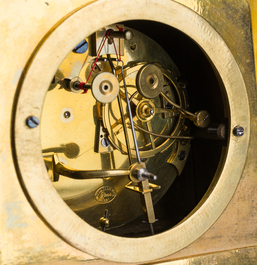A fine French gilt bronze mantel clock crowned with a writing lady, 19th C.