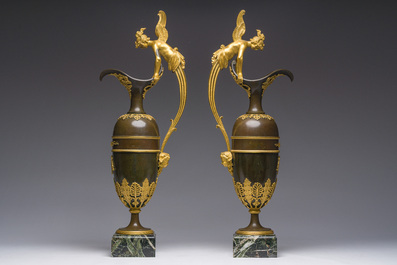 Een imposant paar Franse Empire gepatineerd en verguld bronzen kannen op marmeren sokkels, toegeschreven aan Claude Galle, ca. 1800-1810