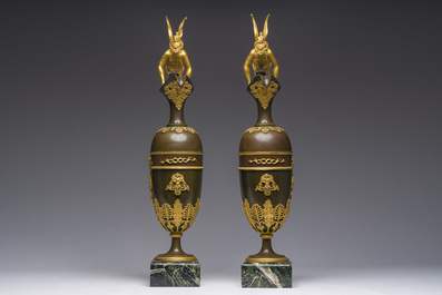 Een imposant paar Franse Empire gepatineerd en verguld bronzen kannen op marmeren sokkels, toegeschreven aan Claude Galle, ca. 1800-1810