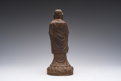 A Chinese cast iron sculpture of a Luohan, probably Ming