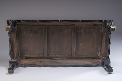 A Chinese rectangular lacquered wooden table with three cloisonn&eacute; plaques, 20th C.