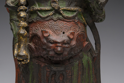 Een Chinese verguld bronzen sculptuur van een wachter met polychroom decor, 18de/19de eeuw