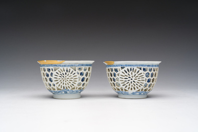 Een paar Chinese blauw-witte opengewerkte dubbelwandige koppen met floraal decor en kintsugi herstelling, Kangxi