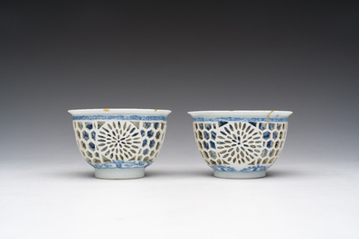 Een paar Chinese blauw-witte opengewerkte dubbelwandige koppen met floraal decor en kintsugi herstelling, Kangxi