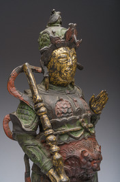 Een Chinese verguld bronzen sculptuur van een wachter met polychroom decor, 18de/19de eeuw