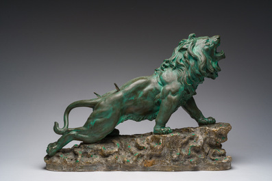 Belgian school, Van den Balck (19th/20th C.): A roaring lion on a rock struck by arrows, green and gray patinated plaster, Brussels