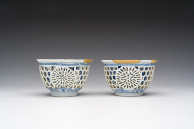 Een paar Chinese blauw-witte opengewerkte dubbelwandige koppen met floraal decor en kintsugi herstelling, Kangxi