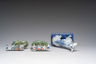 A blue and white Dutch Delft model of a seated dog and a pair of polychrome cows, 19th C.
