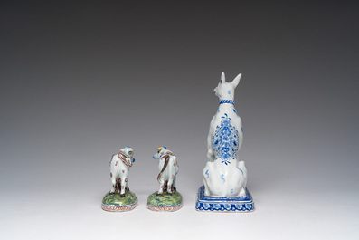 A blue and white Dutch Delft model of a seated dog and a pair of polychrome cows, 19th C.