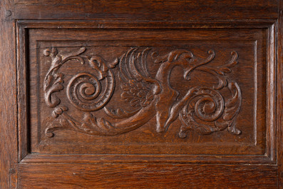 Een Vlaamse eikenhouten vierdeurkast met panelen met spuwende griffioenen, 17de eeuw