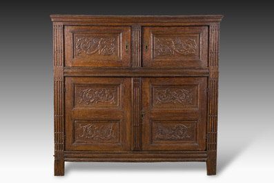 Een Vlaamse eikenhouten vierdeurkast met panelen met spuwende griffioenen, 17de eeuw