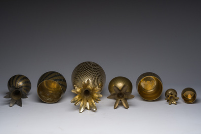 A Hollywood Regency gilt brass 'pharaon' table lamp, Deknudt, Kortrijk, and four Hollywood Regency style pineapples, 20th C.