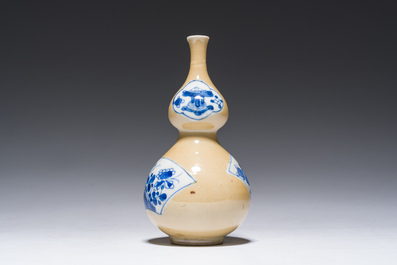A Chinese blue and white caf&eacute;-au-lait-ground double gourd vase, Kangxi