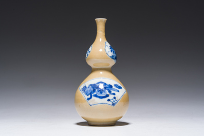 A Chinese blue and white caf&eacute;-au-lait-ground double gourd vase, Kangxi