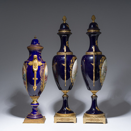 Three French gold layered blue ground gilt bronze mounted S&egrave;vres style vases and covers with gallant scenes, 20th C.