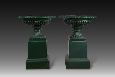 Een paar groengepatineerde gietijzeren tuinvazen op voet, 20ste eeuw