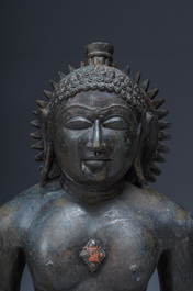 An Indian polished black marble sculpture of a Jina seated in dhyanasana on an ornate cushion, probably Gujarat, 15th C.